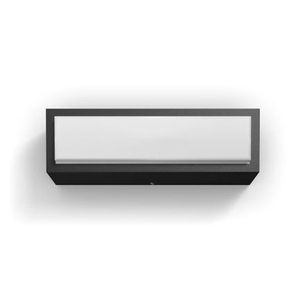 Nástenné svietidlo s obdĺžnikovým tvarom, svieti, je namontované na stene. Svietidlo má čierny rám a biely difúzor.