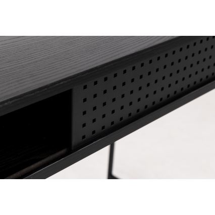 Čierny stolík s otvorovou perforáciou v prednej časti, stoji na dvoch nohách. Je z tmavého dreva s kovovými prvkami. Zobrazuje časť prednej strany s úložným priestorom.