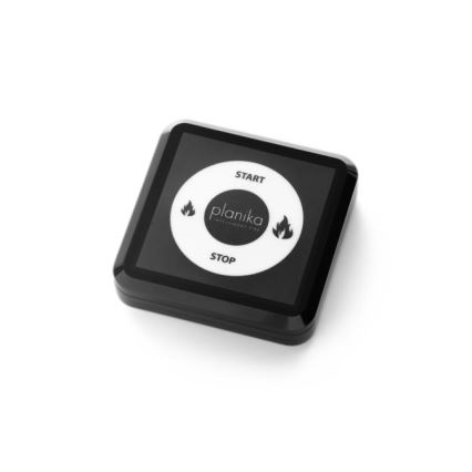 Čierny štvorcový ovládač s bielym displejom ovláda oheň. Displej zobrazuje nápisy „START“, „planika Intelligent Fire“, „STOP“ a dva symboly plameňov. Ovládač leží na bielom pozadí.