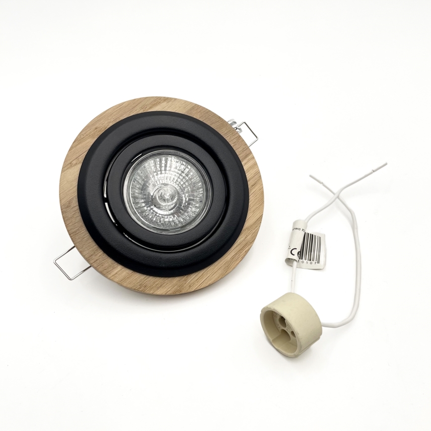 Svietidlo s dreveným a čiernym rámom obsahuje žiarovku. K nemu je pripojená keramická objímka s dvoma drôtmi. Svietidlo je umiestnené na bielom pozadí.