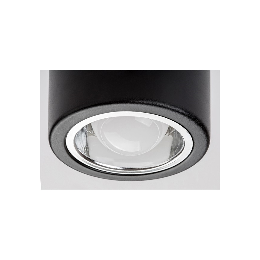 Svietidlo svieti. Je čierne, valcovitého tvaru, s okrúhlym skleneným krytom. Svetlo vychádza z vnútra.