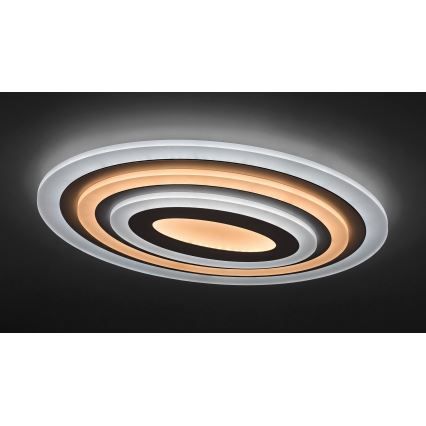 Svietidlo svieti na tmavom strope. Oválne svietidlo má viacero koncentrických kruhov, vnútorný je svetložltý. Vonkajší kruh je priesvitný.