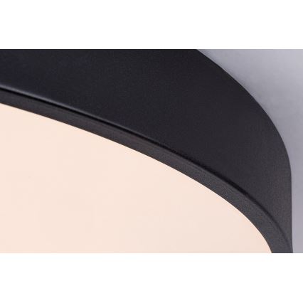 Svietidlo svieti. Má čierny vonkajší okraj a svetložltý vnútorný difúzor. Je pripevnené k stropu.