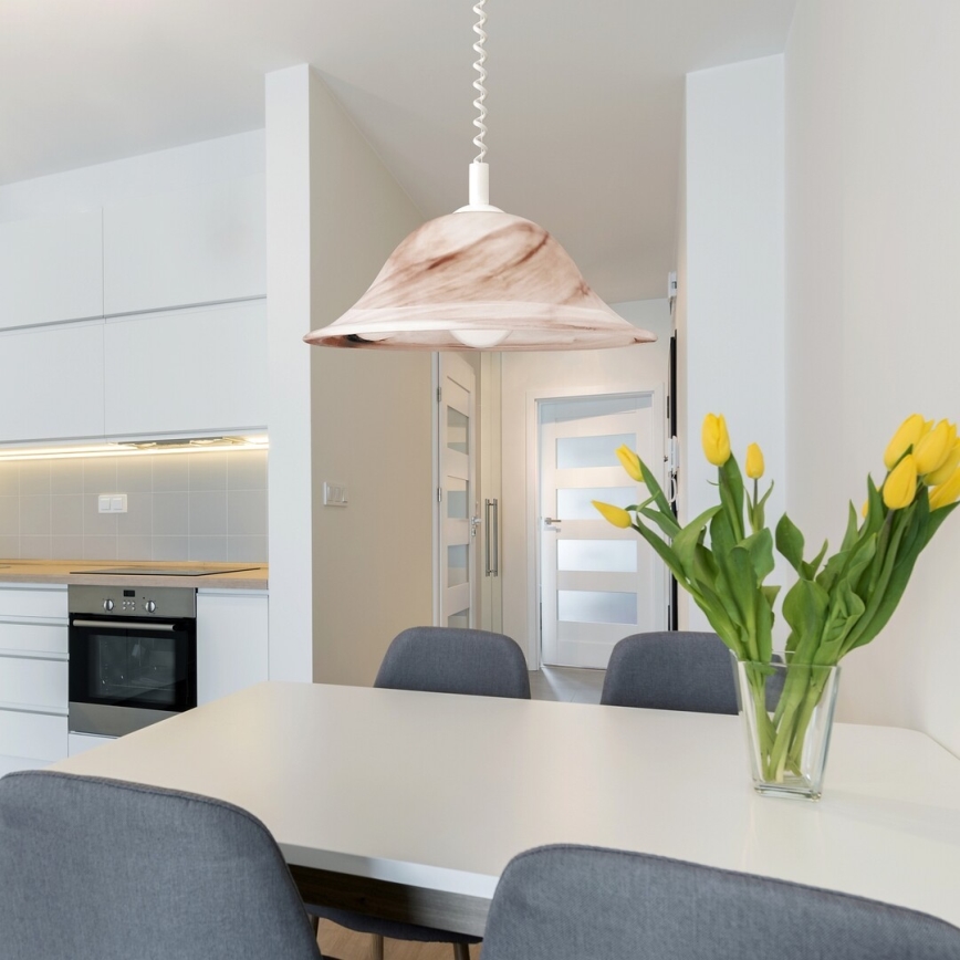 Svetlo béžová stropná lampa svieti nad jedálenským stolom v modernej kuchyni. Štyri stoličky obklopujú stôl, na ktorom je váza s žltými tulipánmi. V pozadí je kuchynská linka a dvere do ďalšej miestnosti.