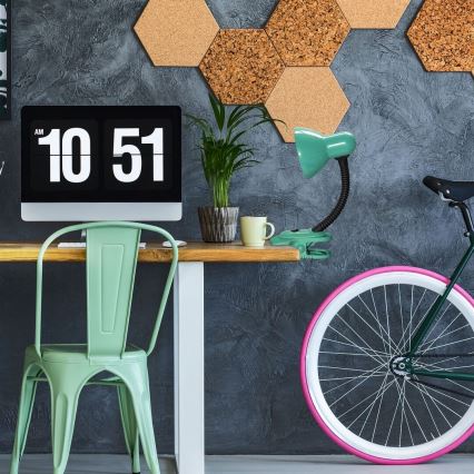 Stolová lampa - pripevnená na stôl - v pracovni s počítačom a bicyklom. Na monitore je čas 10:51.