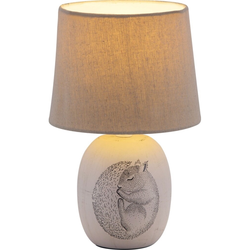 Stolová lampa s textilným tienidlom svieti. Na keramickom podstavci je potlačený spiace veverička. Lampa je umiestnená na bielom pozadí.
