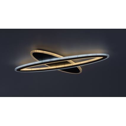 Svietidlo svieti na strope. Dva prelínajúce sa oválne panely, jeden čierny a druhý s bielym LED osvetlením. Pozadí je tmavosivé.