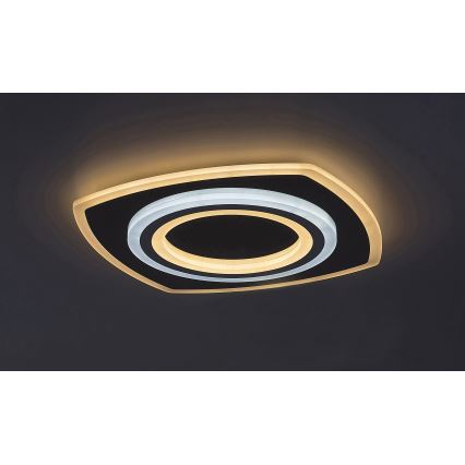 Svietidlo svieti na tmavom strope. Má štvorcový tvar s vnútorným kruhovým dizajnom a dvojitým okrajom, ktorý svieti teplým bielym a studeným bielym svetlom.