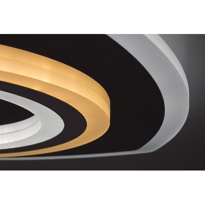 Svietidlo svieti na tmavom pozadí. Má konštrukciu z prekrývajúcich sa kruhov v čiernej, bielej a svetložltej farbe. Svetlo vyžaruje zo svetložltých prvkov.