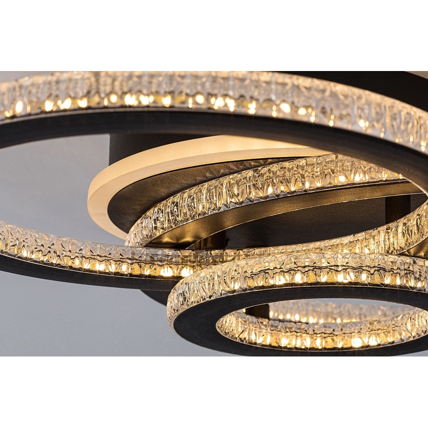 Svietidlo svieti. Je tvorené niekoľkými prekrývajúcimi sa čiernymi kruhmi, osadenými kryštálikmi, ktoré obklopujú svetelný zdroj. Konštrukcia je moderná.