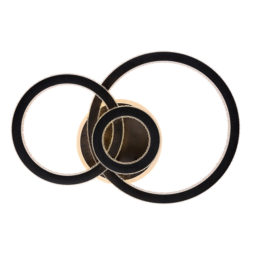 Svietidlo s prepletenými čiernymi kruhmi a zlatým stredom visí na bielom pozadí. Kruhy sú zdobené drobnými kryštálikmi. Svietidlo je zavesené.