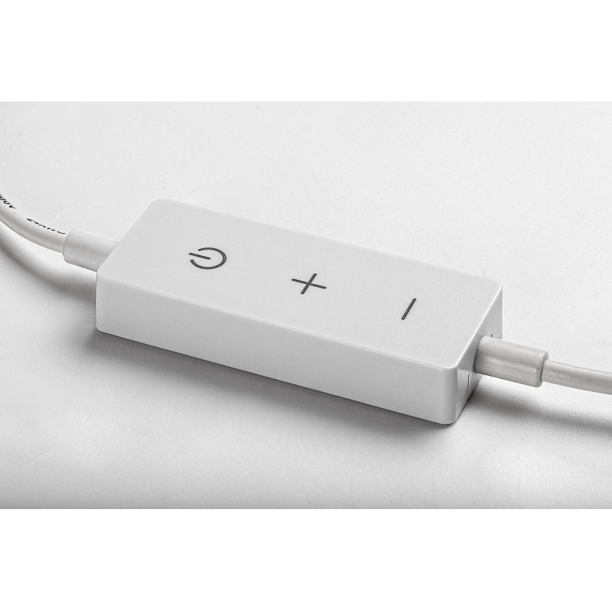 Biela obdĺžniková krabička s káblom má tlačidlá zapnutia/vypnutia a plus/mínus. Leží na svetlom povrchu.