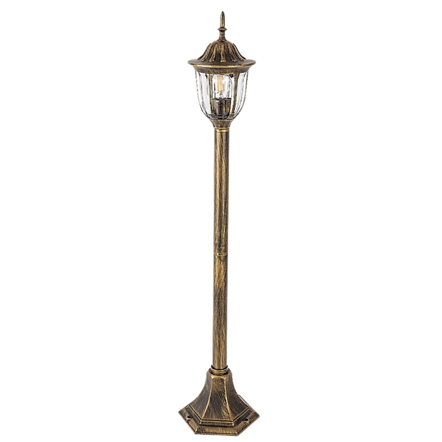 Záhradná lampa stojí na kamennej dlažbe. Okolité prostredie tvorí kvitnúci ker hortenzií a záhradný nábytok, vrátane dvoch oranžových kresiel.