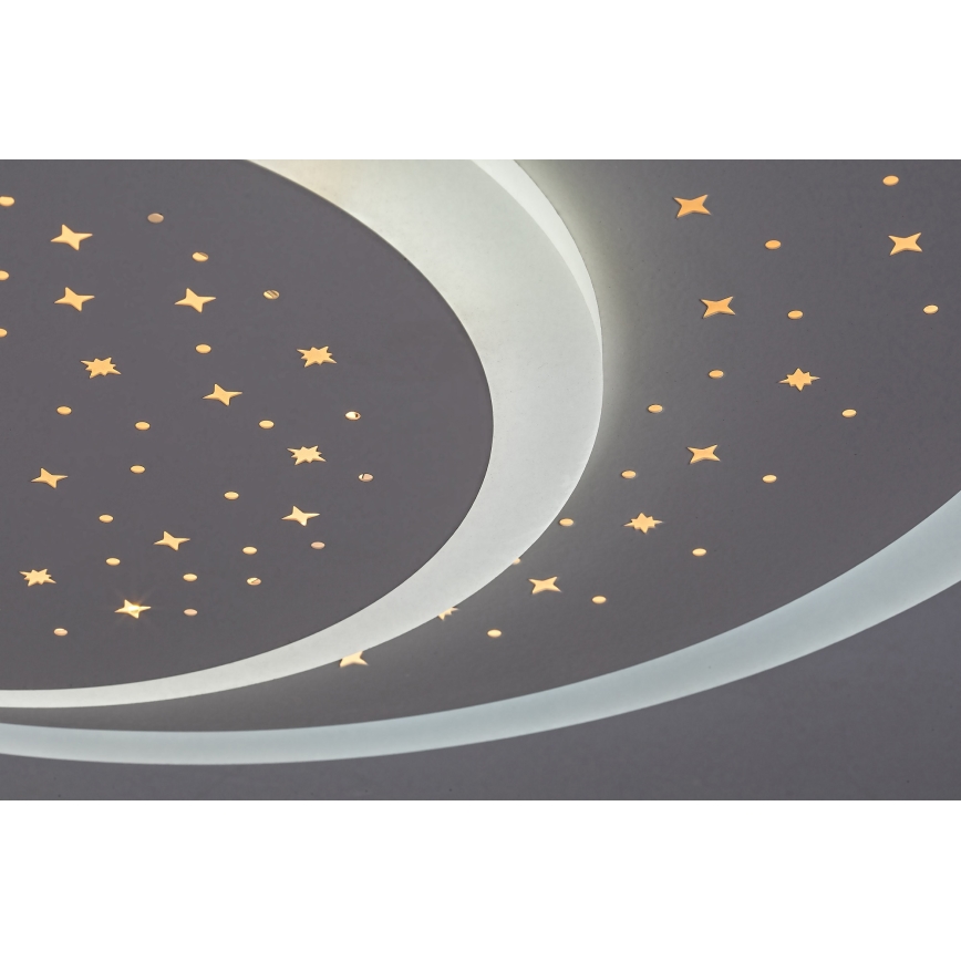 Svietidlo v tvare polmesiaca svieti. Je osadené na strope a má vyrezávané hviezdičky, ktoré vyžarujú svetlo. Strop je tmavosivá.