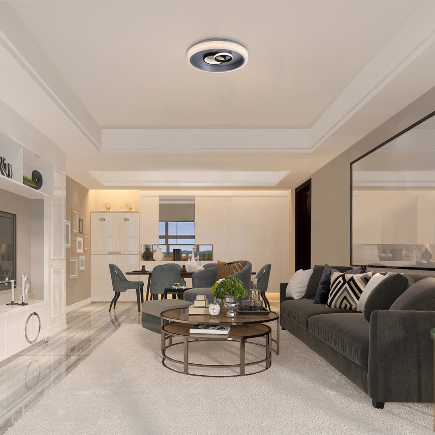 Stropný ventilátor s osvetlením je umiestnený v strede obývacej izby s moderným nábytkom a svetlými stenami. Ventilátor je zapustený do stropu. Izba obsahuje sedaciu súpravu, konferenčný stolík a jedálenskú časť.