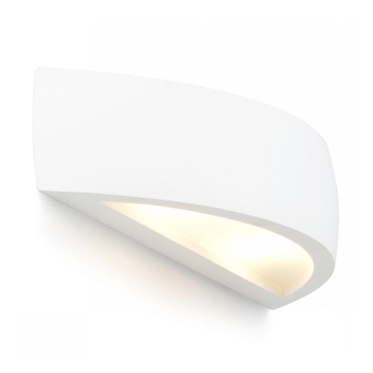 Biela nástenná lampa svieti. Jej tvar pripomína zakrivený obdĺžnik s trojuholníkovým otvorom, z ktorého vychádza svetlo. Lampa je umiestnená na bielej stene.
