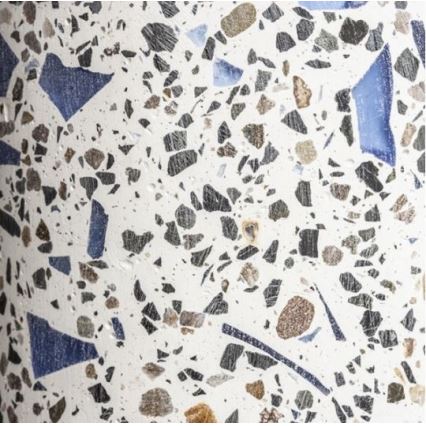Terazzová plocha je zložená z drobných kúskov kameňa v bielej, sivej a modrej farbe, zapustených do svetlej cementovej zmesi.