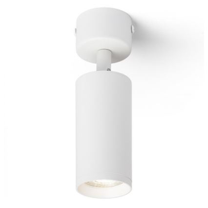 Biela cylindrická bodová lampa je pripevnená k stropu. Svieti. Lampa je umiestnená na bielom pozadí.