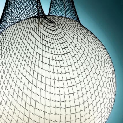 Biela guľa je obalená čiernou sieťou. Sieť je zvrásnená a vytvára nerovnomerný povrch. Pozadie je bledomodré.