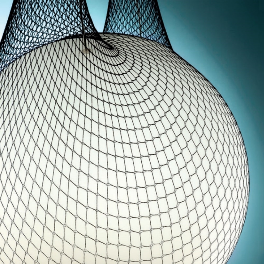 Biela guľa je obalená čiernou sieťou. Sieť je zvrásnená a vytvára nerovnomerný povrch. Pozadie je bledomodré.