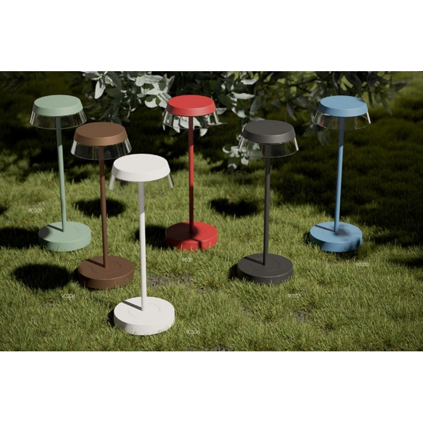 Šesť stojacích svietidiel s tienidlami v rôznych farbách (zelená, hnedá, biela, červená, čierna, modrá) stojí na trávnatom povrchu. Pod každým svietidlom je malý kód.