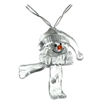 Priehľadná snehuliaková ozdoba s červeným nosom a čapicou visí na drôtiku. Snehuliak má na sebe šál a drží lyže. Ozdoba je na bielom pozadí.