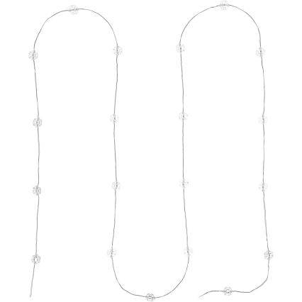 Svetelný reťaz s malými guľôčkami sa vinie dvoma oblúkmi na bielom pozadí. Guľôčky sú pripevnené na tenkom striebornom drôte.