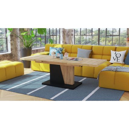 Rozťahovací konferenčný stolík s drevenou doskou a čiernou podnožou stojí v obývacej izbe na tmavomodrom koberci pred žltou sedačkou. Na stolíku sú dekoratívne predmety.