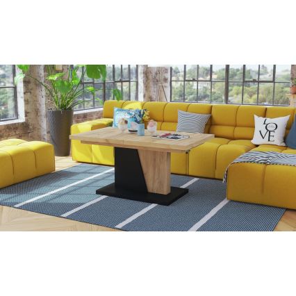 Rozťahovací konferenčný stolík stojí pred žltou sedačkou v obývacej izbe. Stolík je z dreva a má čierny podstavec. Na stole sú dekoračné predmety.