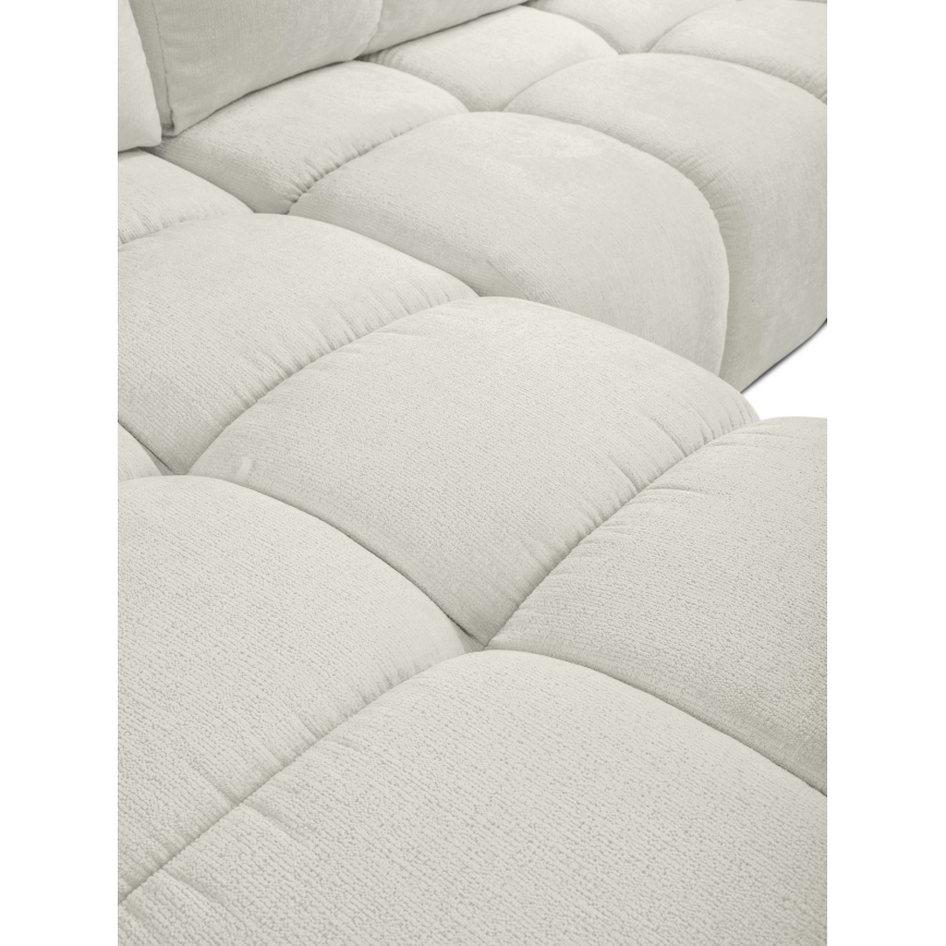 Rohová sedačka je v svetlosivej farbe. Jej povrch je štruktúrovaný do pravidelných štvorcov. Sedačka je zachytená zblízka, takže okolie nie je viditeľné.