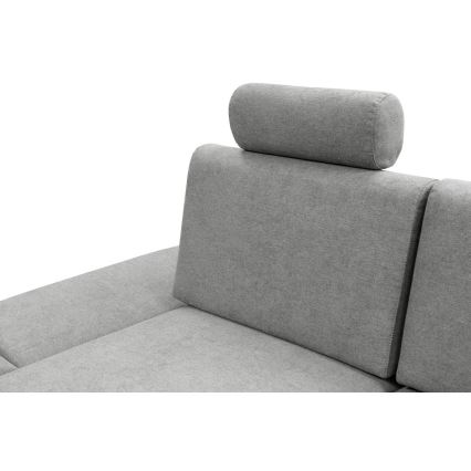 Sivá rohová sedačka s opierkami hlavy a valčekovými vankúšikmi je na fotografii zobrazená zblízka. Opierka je potiahnutá svetlosivou látkou.