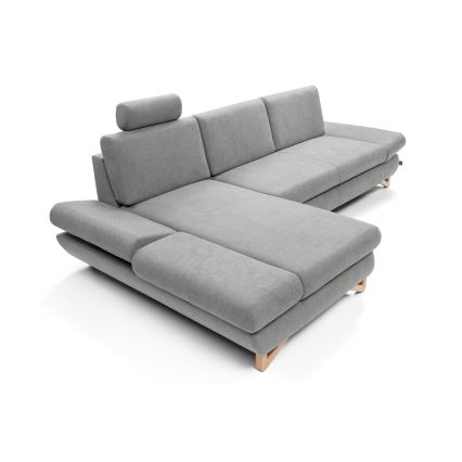 Rohová sedačka sivého čalúnenia stojí na svetlom drevenom podstavci. Sedačka má niekoľko sedacích častí a opierky na ruky. Nachádza sa na bielom pozadí.