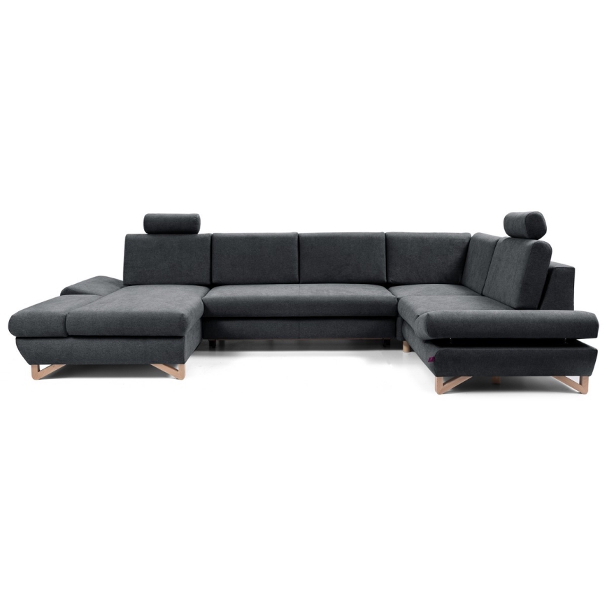 Rohová sedačka s opierkami hlavy stojí na bielom pozadí. Sedačka je tmavosivá, s drevenými nožičkami. Je rozložená do tvaru písmena U.