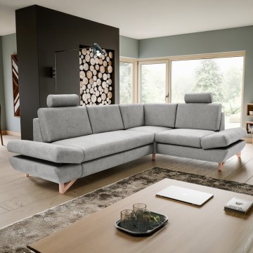 Rohová sedačka sivého čalúnenia s drevenými nožičkami stojí na svetlom pozadí. Sedačka má opierky hlavy a je rozdelená do troch častí.