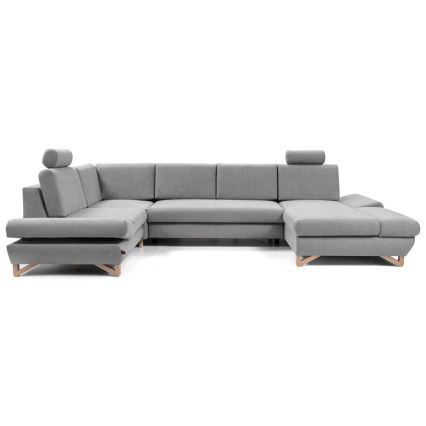 Rohová sedačka v tvare U, sivá, stojí na drevených nožičkách. Je rozdelená na niekoľko častí, má opierky hlavy. Nachádza sa na bielom pozadí.