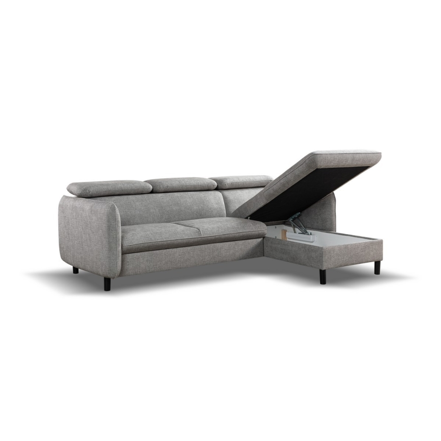 Rohová sedačka s otvoreným úložným priestorom v pravom rohu. Sedačka je svetlošedá, látková, na nízkych nohách. Je umiestnená na bielom pozadí.