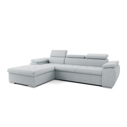 Rohová sedačka svetlošedej farby je umiestnená v moderne zariadenej obývacej izbe. Sedačka má rohový tvar s opierkami a je položená na svetlej podlahe pred nízkym odkladacím stolíkom. Izba obsahuje aj obrazy a rastliny.