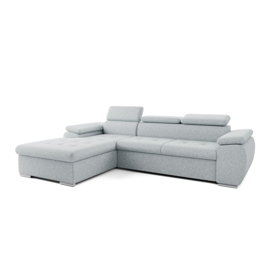 Rohová sedačka svetlošedej farby je umiestnená v moderne zariadenej obývacej izbe. Sedačka má rohový tvar s opierkami a je položená na svetlej podlahe pred nízkym odkladacím stolíkom. Izba obsahuje aj obrazy a rastliny.