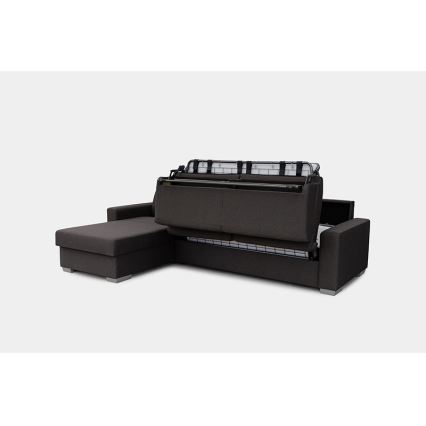 Rozkladacia rohová sedačka s výsuvným lôžkom sa rozkladá, odhaľujúc kovový rošt. Sedačka je tmavosivá, s jednoduchým dizajnom a je umiestnená na svetlom pozadí.