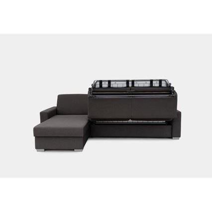 Rohová sedačka s rozkladacím mechanizmom ukazuje výsuvný matrac. Sedačka je tmavosivá, na svetlom pozadí.