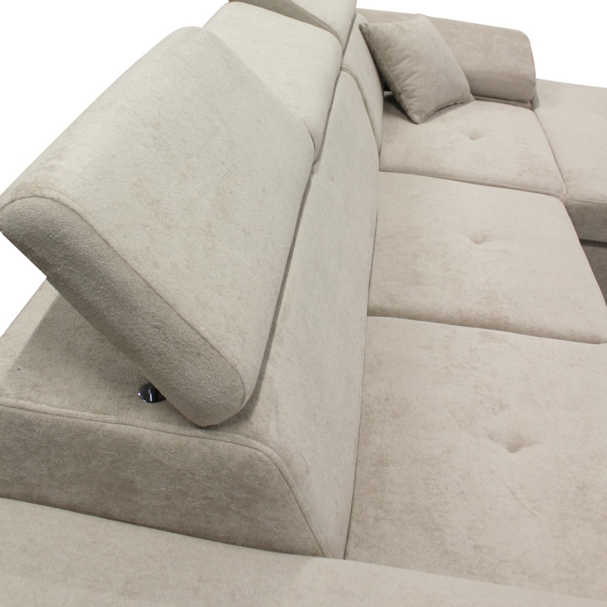 Rohová sedačka s nastaviteľnými opierkami hlavy je čalúnená svetlo béžovou látkou. Opierky sa dajú sklápět. Sedačka má gombíkové prešívanie na sedákoch.