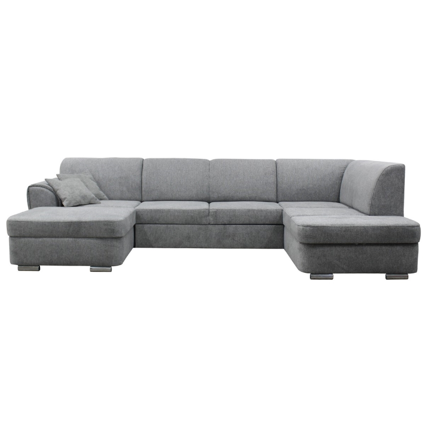 Rohová sedačka sivá s podrúčkami a vankúšom je umiestnená na bielom pozadí. Sedačka je rozsiahla, s viacerými sedacími časťami. Je zhotovená z látky.