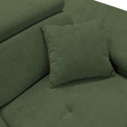 Rohový gauč tmavozelenej farby je doplnený vankúšom. Opierky sú mäkké a textúrované. Gauč je zobrazený zblízka.