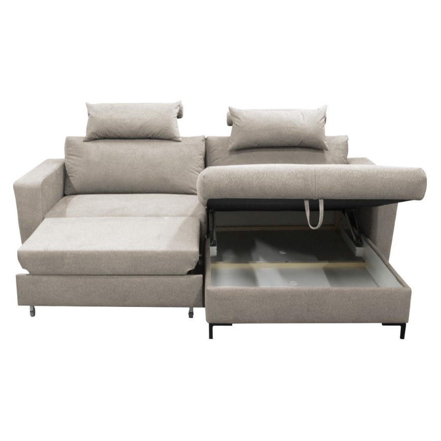 Rohová sedačka s výsuvným úložným priestorom je rozložená. Sedačka je svetlo béžovej farby, má dva vankúše a je na bielom pozadí.