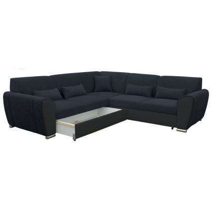 Rohová sedačka tmavomodrej látky s výsuvným úložným priestorom je zobrazená na bielom pozadí. Sedačka má niekoľko vankúšov a kontrastné čierne prvky. Je v rozloženom stave, pričom je viditeľný výsuvný šuflík.