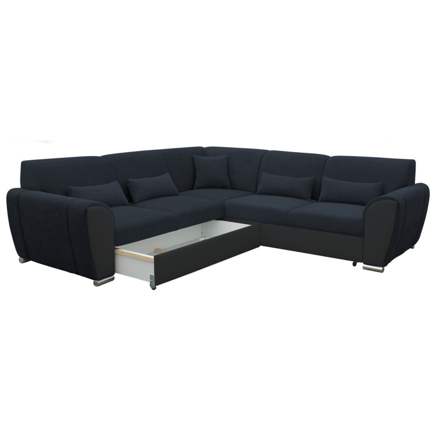 Rohová sedačka tmavomodrej látky s výsuvným úložným priestorom je zobrazená na bielom pozadí. Sedačka má niekoľko vankúšov a kontrastné čierne prvky. Je v rozloženom stave, pričom je viditeľný výsuvný šuflík.