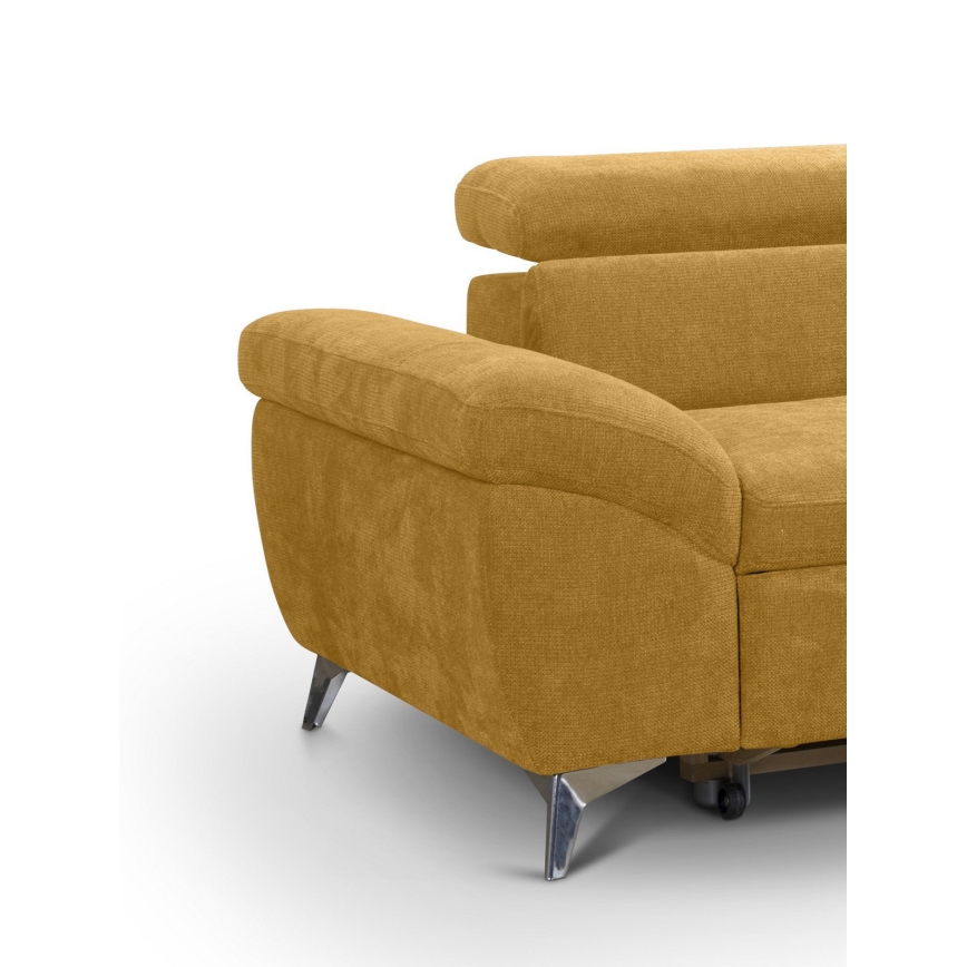 Rohový gauč v horčicovej farbe stojí na tenkých kovových nožičkách. Je čalúnený textíliou a má zaoblené opierky. Gauč je detailne zobrazený z bočného uhla.