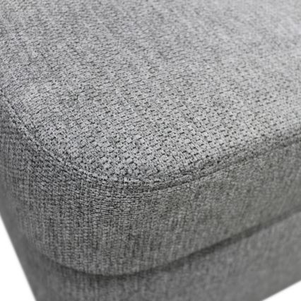 Sivý čalúnený nábytok s textúrovaným poťahom. Horná časť je vyobrazená detailne, vidno štruktúru látky. Pozornosť sa sústreďuje na detail povrchu.