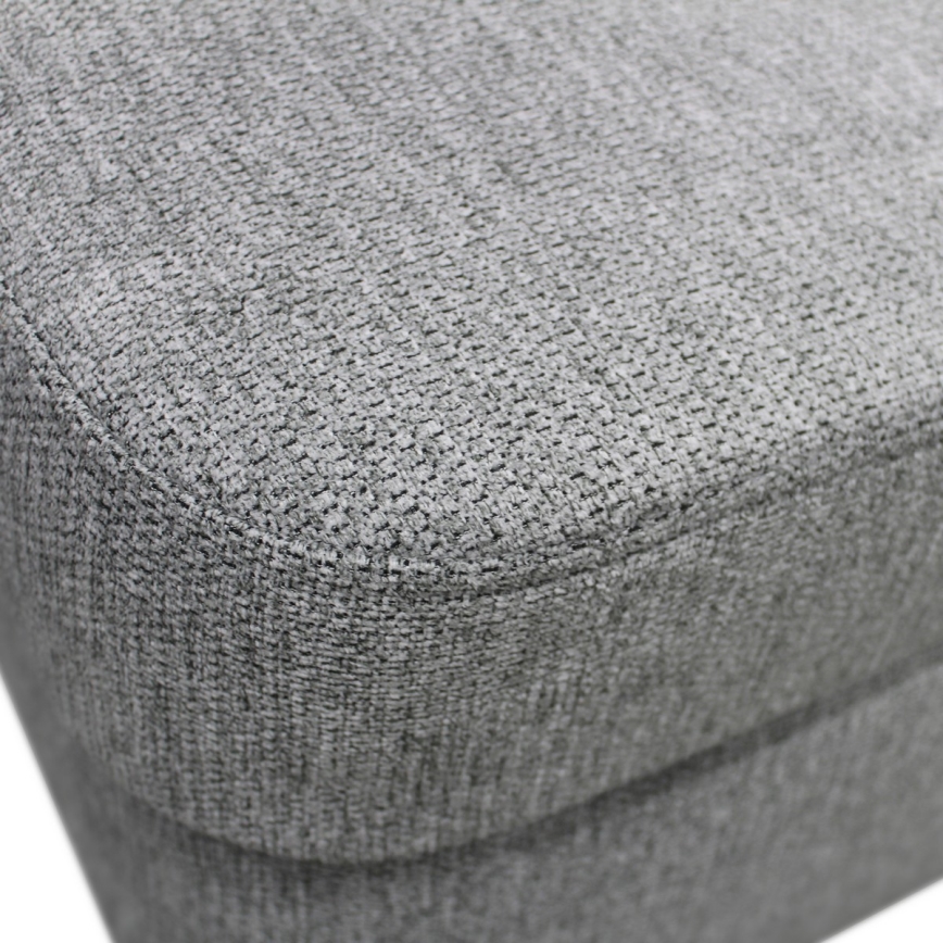Sivý čalúnený nábytok s textúrovaným poťahom. Horná časť je vyobrazená detailne, vidno štruktúru látky. Pozornosť sa sústreďuje na detail povrchu.