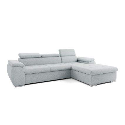 Rohová sedačka svetlošedej farby stojí v moderne zariadenej obývacej izbe. Sedačka je umiestnená na svetlej koberci pred nízkym konferenčným stolíkom. V pozadí je vidieť okno s výhľadom do prírody a časť steny s obrazom a nábytkom.